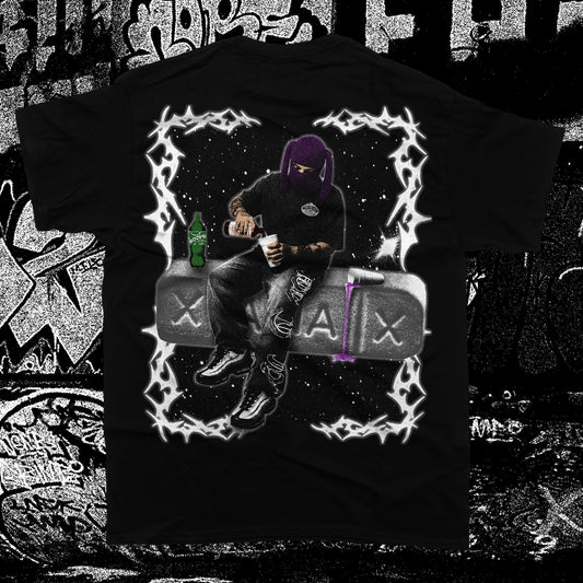 A black short-sleeve graphic t-shirt featuring a stylized illustration of a person in a purple hoodie sitting on a gray vehicle, framed by a white lightning border. The shirt is displayed against a black-and-white graffiti wall background.
